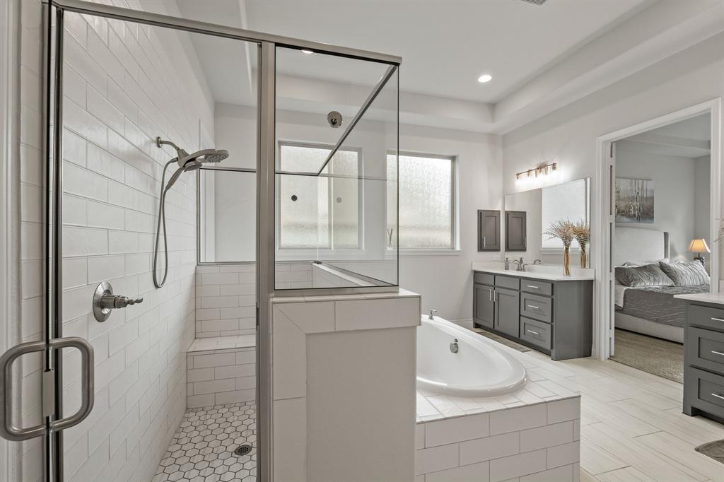 11504 Antler Ridge Way Argyle, TX 76226 - Photo 28 of 40 a bathroom with a granite countertop sink a mirror a bathtub and shower