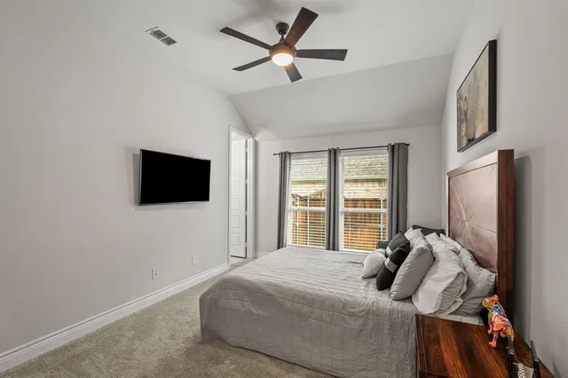 a bed room with a bed tv and a window