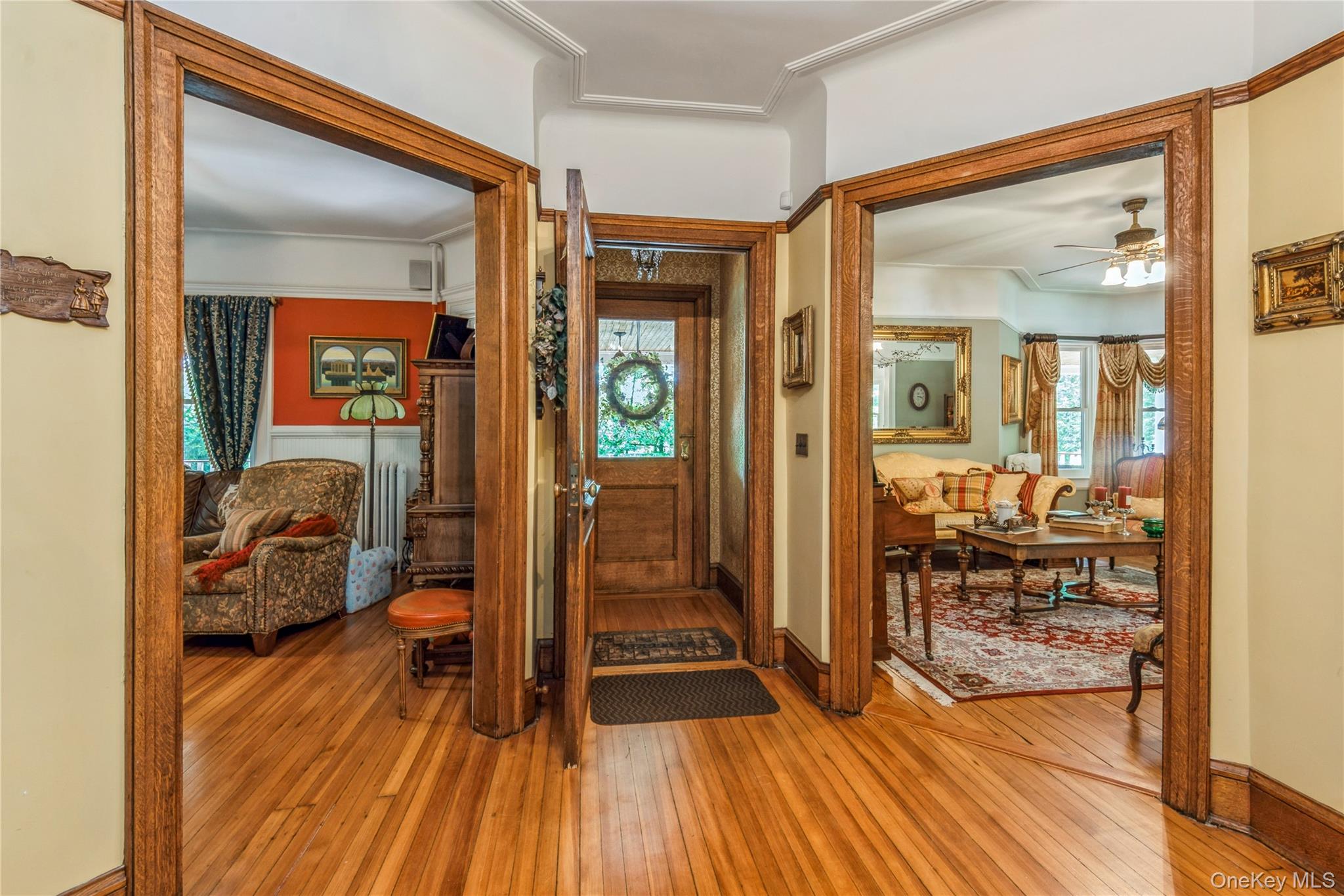 110 Red Spring Lane Glen Cove, NY 11542 - Photo 11 of 43 Hardwood flooring throughout the entry area, featuring ornate wood door frames and crown molding