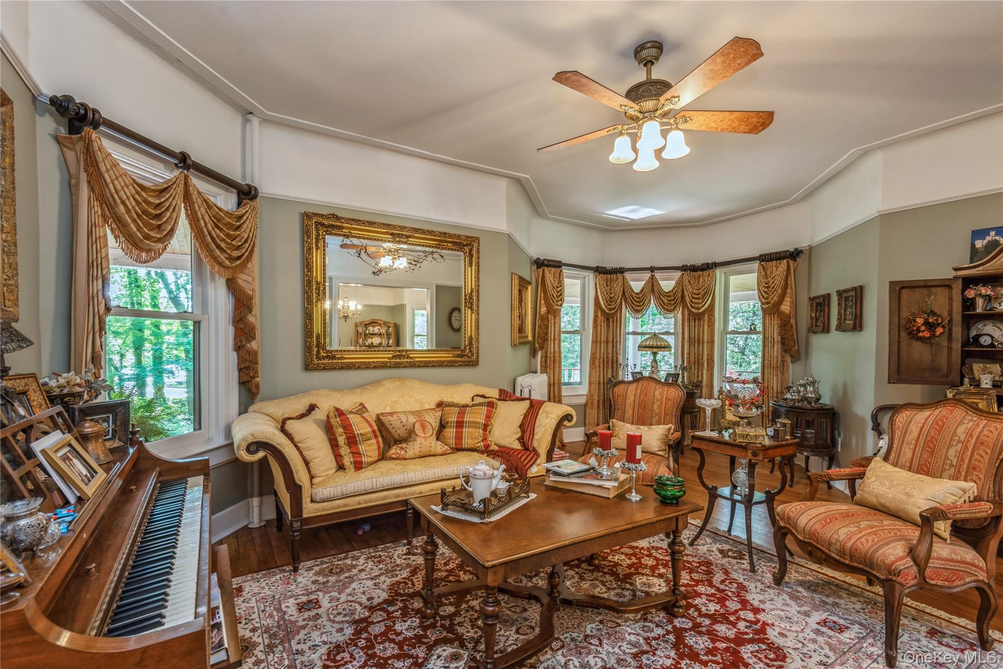 110 Red Spring Lane Glen Cove, NY 11542 - Photo 12 of 43 Formal living area featuring a bay window, wood-finish flooring, and a ceiling fan with integrated lighting