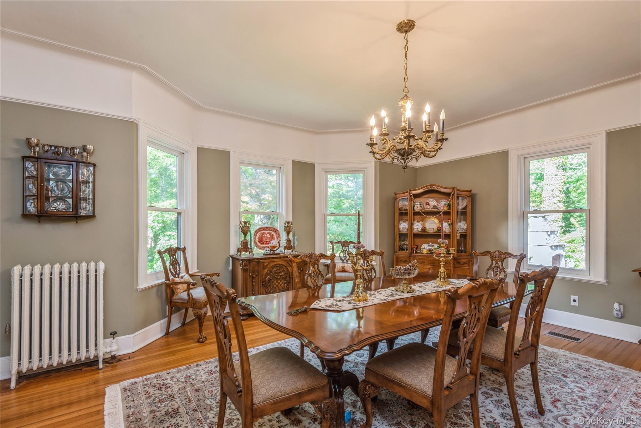 110 Red Spring Lane Glen Cove, NY 11542 - Photo 16 of 43 Formal dining room, complemented by a cast iron radiator and a classic chandelier