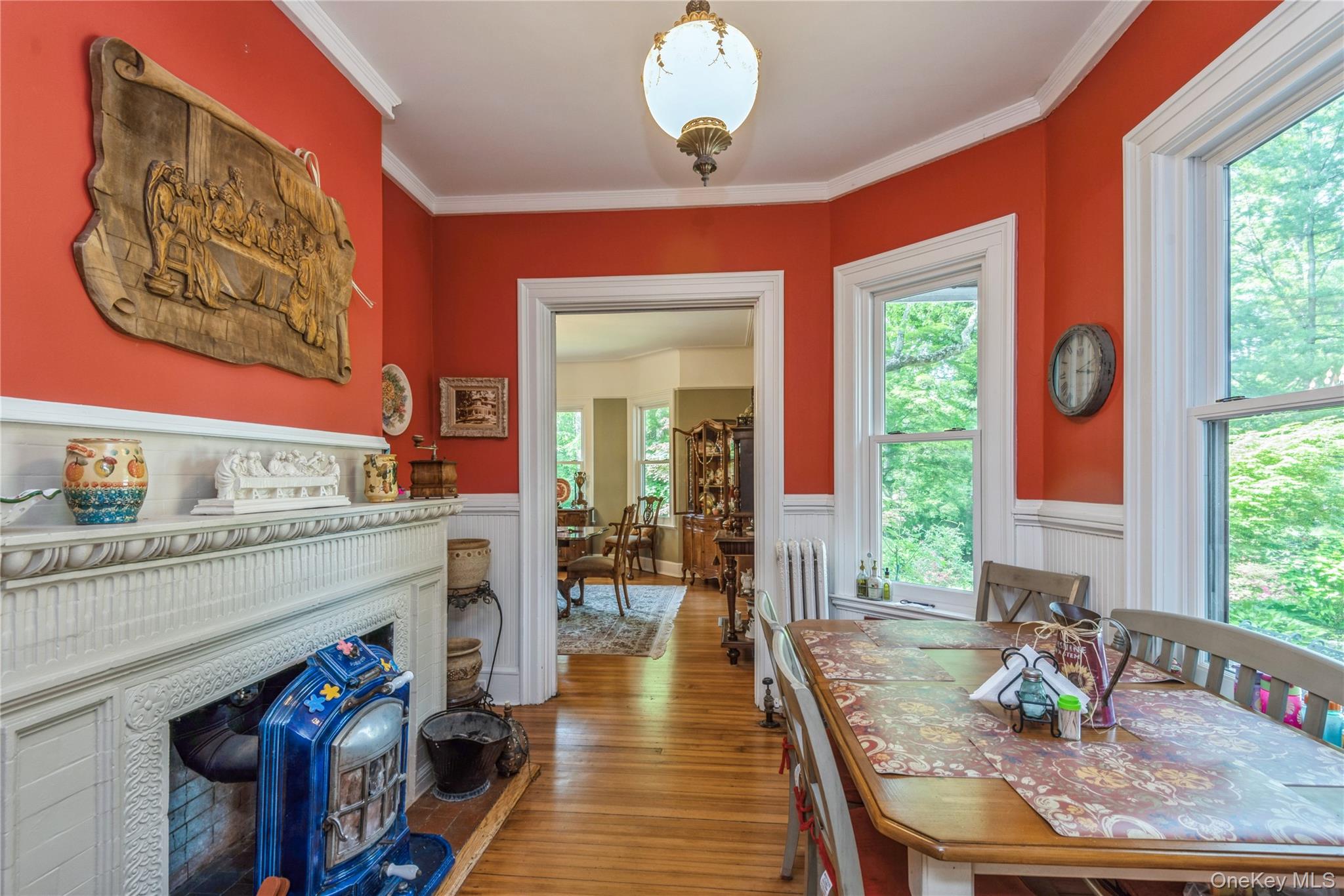 110 Red Spring Lane Glen Cove, NY 11542 - Photo 19 of 43 Breakfast room featuring hardwood flooring, white wainscoting, and a decorative fireplace