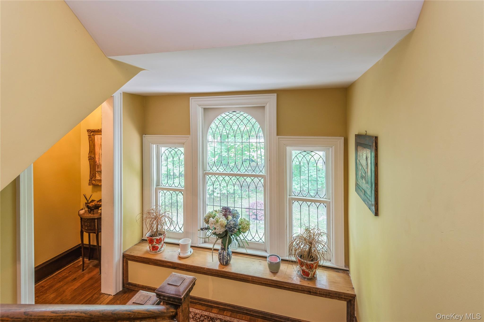 110 Red Spring Lane Glen Cove, NY 11542 - Photo 29 of 43 Ornate window alcove featuring three windows with decorative muntins, a central arched window, and a built-in wood window seat