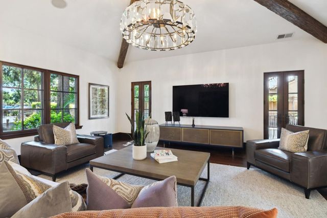 a bedroom with a large bed a chandelier and a couch