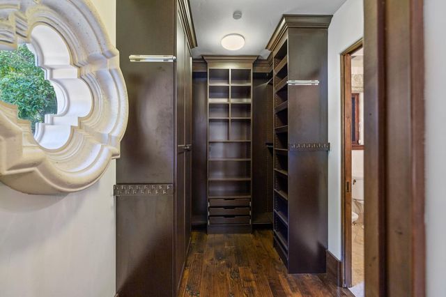 a spacious bedroom with a large bed a chandelier and windows