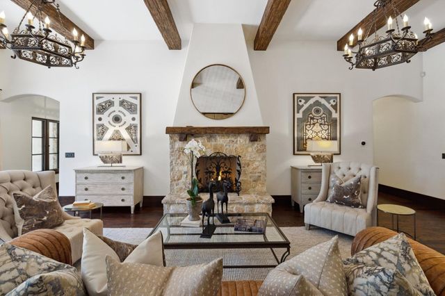 a living room with furniture a fireplace and a chandelier