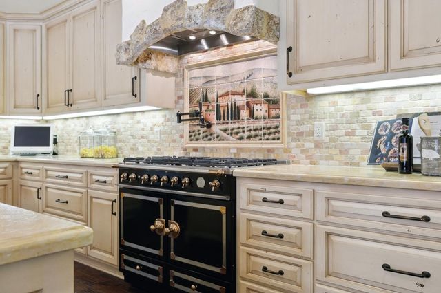 a kitchen with a stove cabinets and window