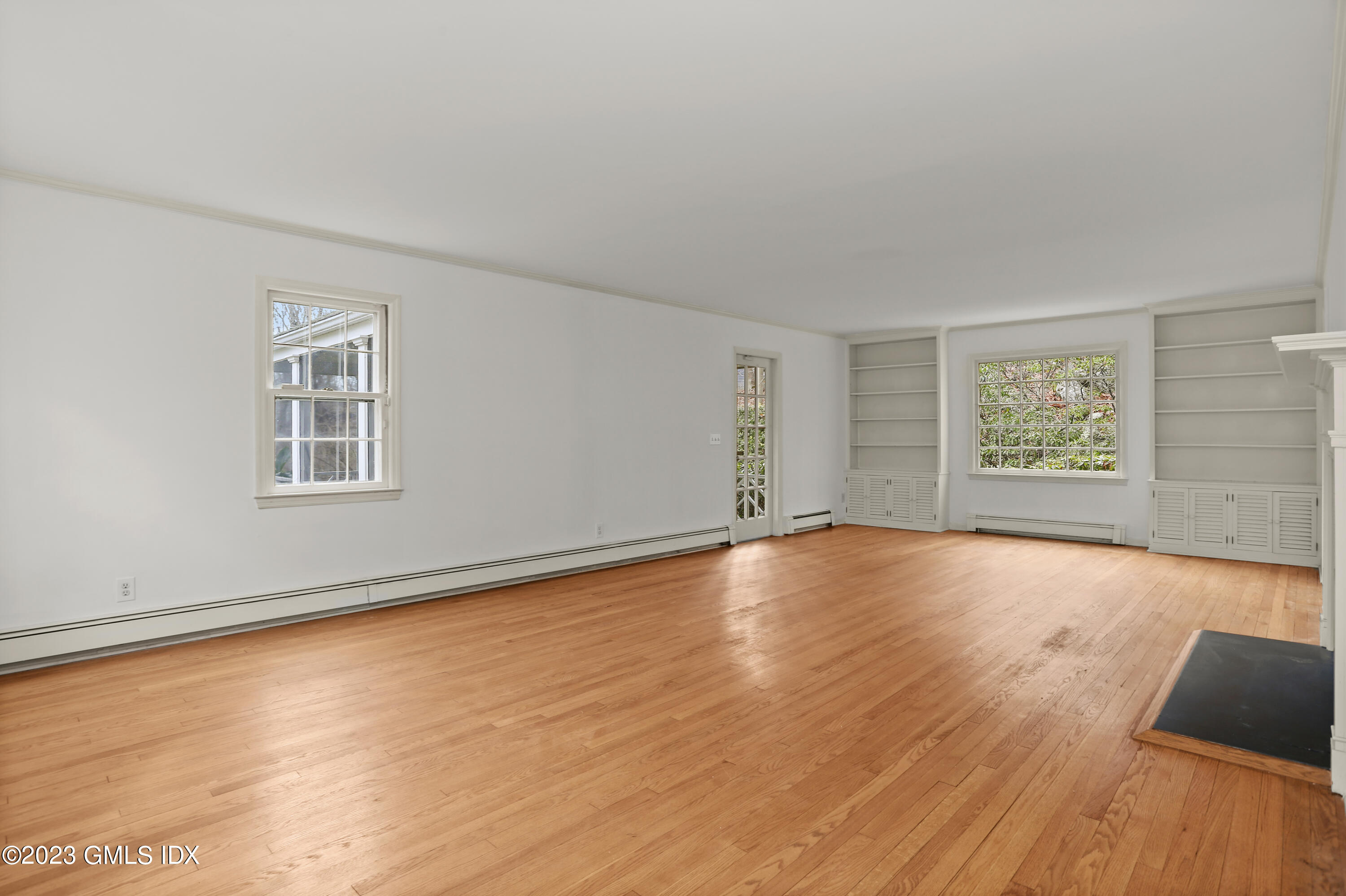 55 Frontier Road Cos Cob, CT 06807 - Photo 12 of 38 a view of an empty room with wooden floor and a window
