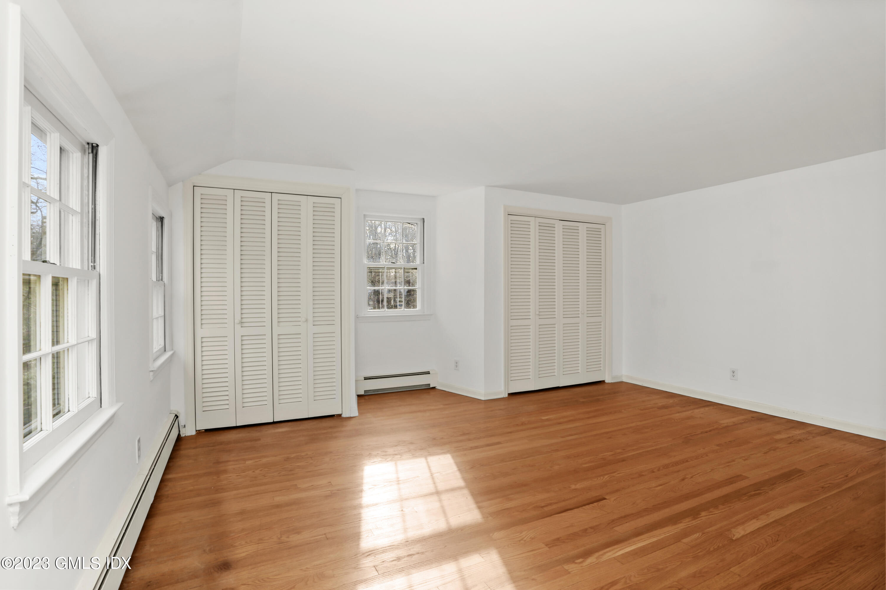 55 Frontier Road Cos Cob, CT 06807 - Photo 22 of 38 a view of an empty room with wooden floor and a window