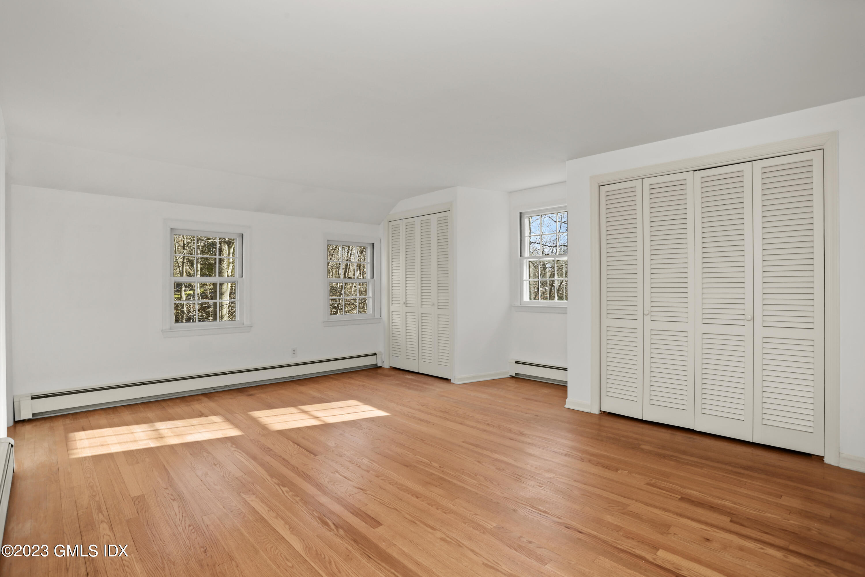 55 Frontier Road Cos Cob, CT 06807 - Photo 23 of 38 an empty room with wooden floor and windows