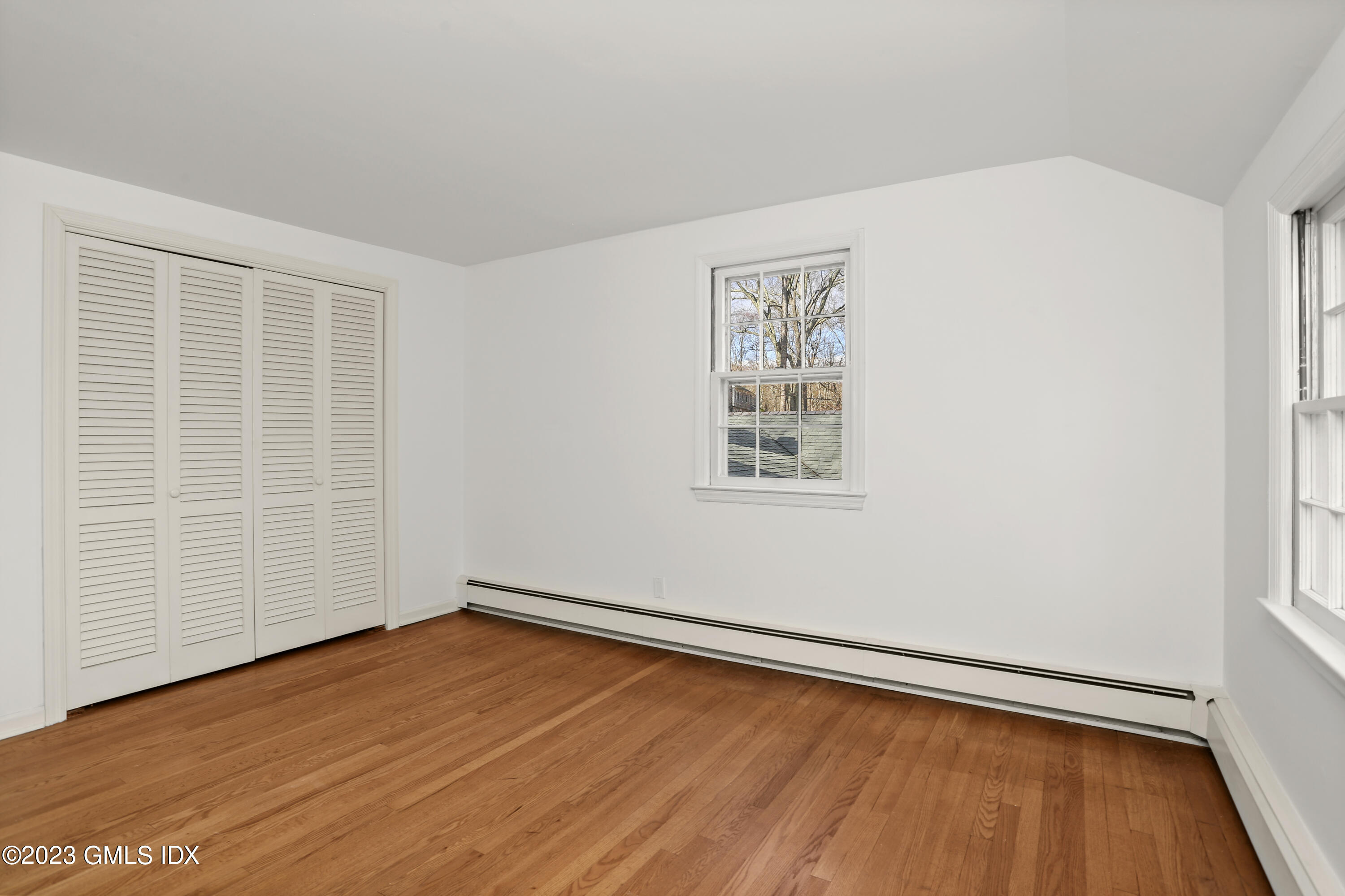55 Frontier Road Cos Cob, CT 06807 - Photo 25 of 38 an empty room with wooden floor and windows
