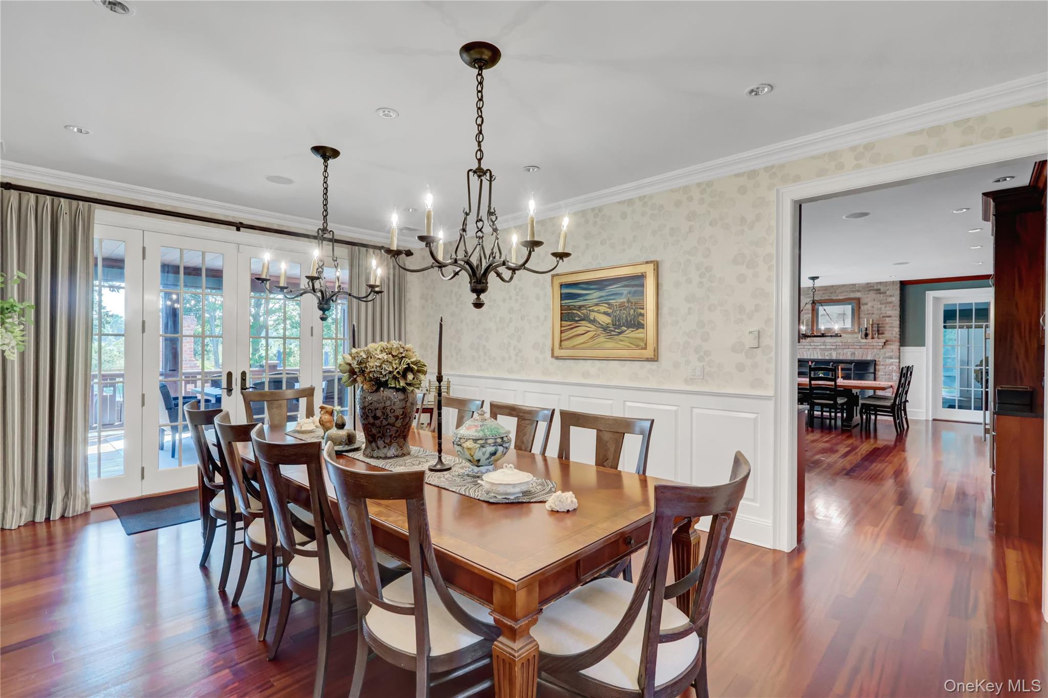 63 Dyke Road Setauket, NY 11733 - Photo 9 of 49 Dining room featuring wallpapered walls, a wainscoted wall, dark wood finished floors, crown molding, and a decorative wall