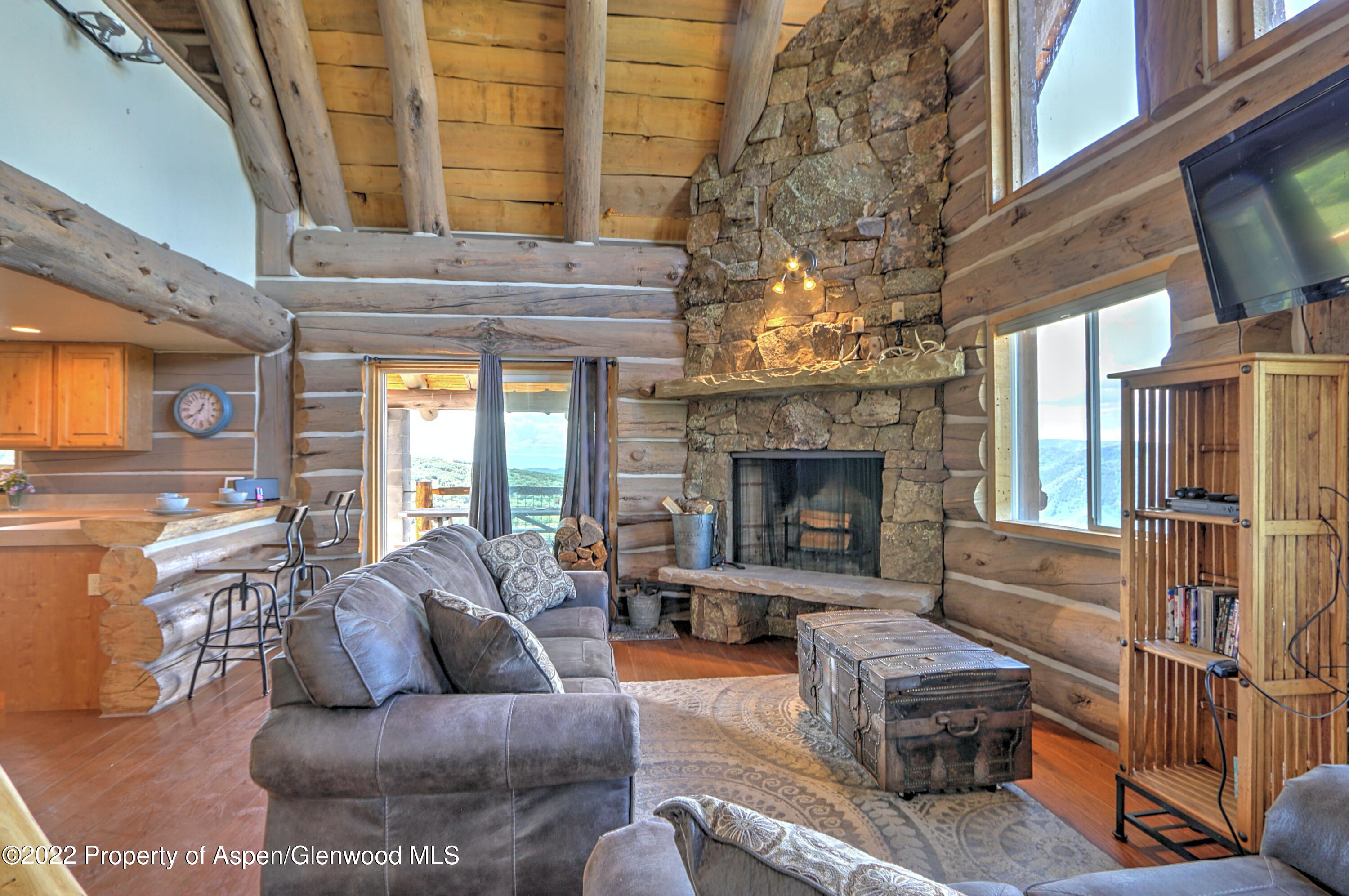 10 Wild Acres Ranch Road Rifle, CO 81650 - Photo 9 of 37 a living room with furniture a fireplace and a large window
