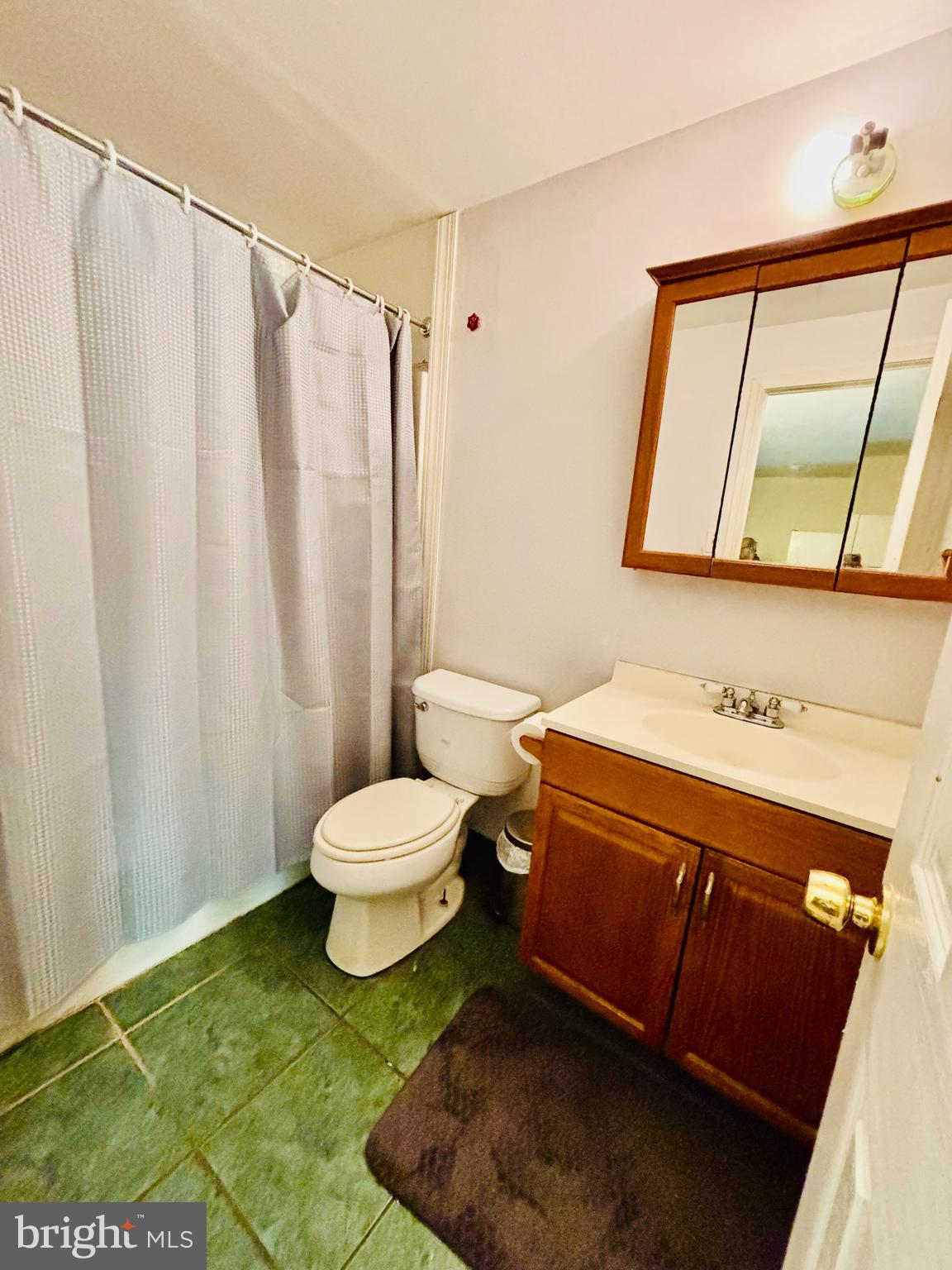 9336 Neil Road, Unit B Philadelphia, PA 19115 - Photo 33 of 37 a bathroom with a sink a toilet and a mirror