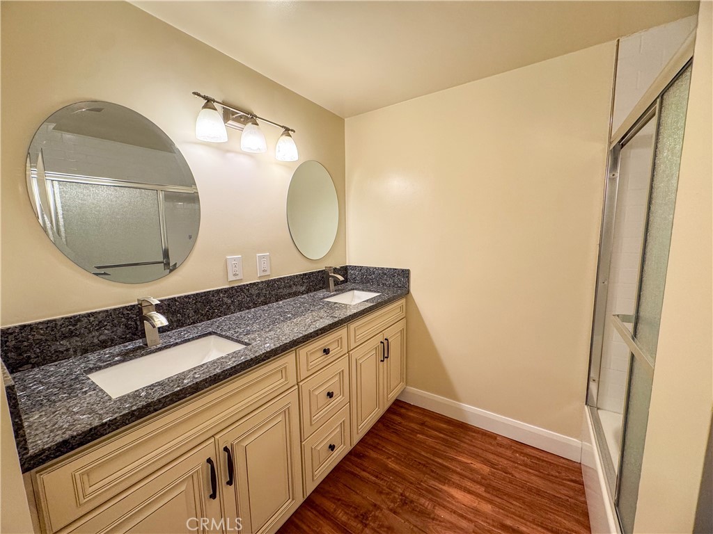 12162 Bradford Place Granada Hills, CA 91344 - Photo 14 of 27 a bathroom with a granite countertop double vanity and a mirror