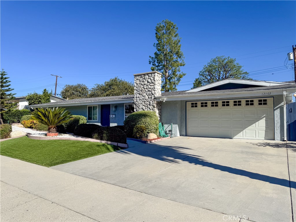 12162 Bradford Place Granada Hills, CA 91344 - Photo 27 of 27 a front view of a house with a yard and garage
