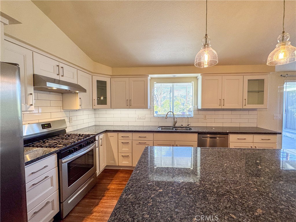 12162 Bradford Place Granada Hills, CA 91344 - Photo 6 of 27 a kitchen with stainless steel appliances granite countertop a stove a sink and a refrigerator