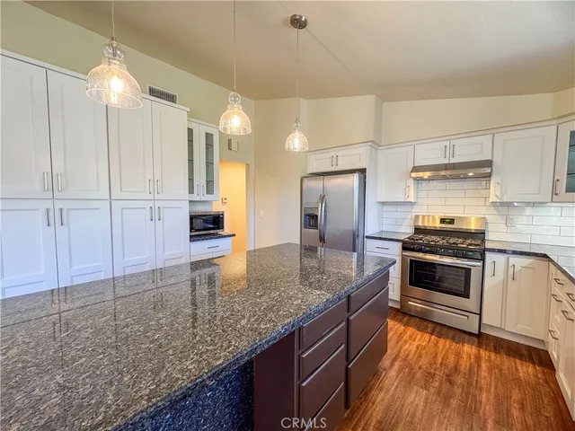 a kitchen with kitchen island granite countertop a stove and a sink