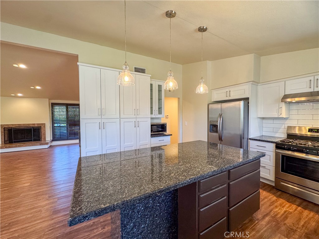 12162 Bradford Place Granada Hills, CA 91344 - Photo 9 of 27 a kitchen with stainless steel appliances granite countertop a sink stove and refrigerator