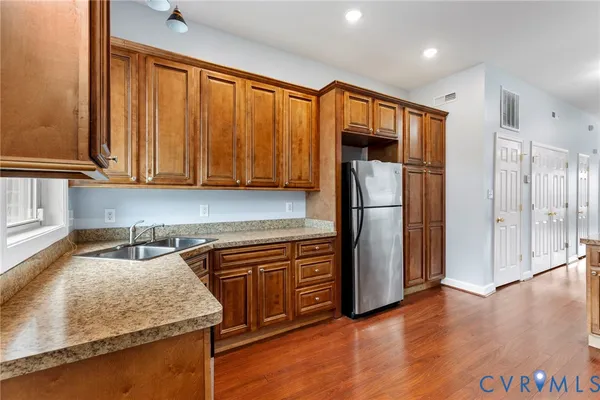 a kitchen with stainless steel appliances granite countertop a refrigerator and a sink
