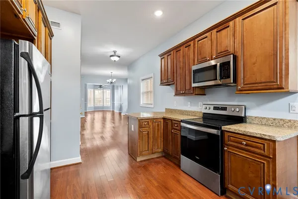 a kitchen with stainless steel appliances granite countertop a stove a sink and a microwave
