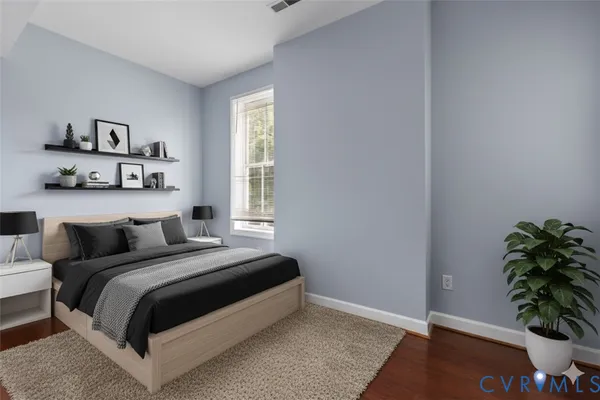 a bedroom with a bed and a potted plant