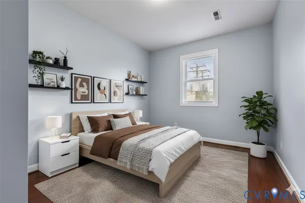 a bedroom with a large bed and a potted plant
