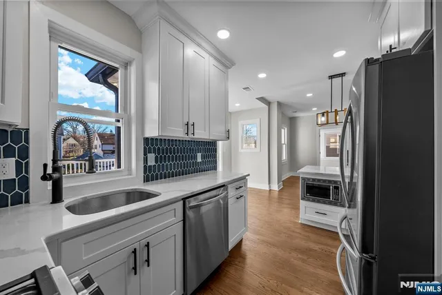 a kitchen with stainless steel appliances granite countertop a refrigerator and a sink