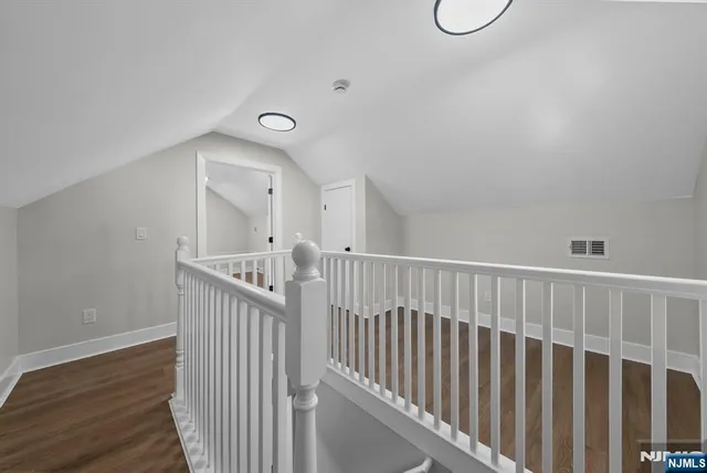 a view of a hallway with wooden floor and stairs