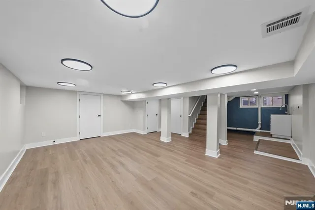 an empty room with wooden floor and white walls