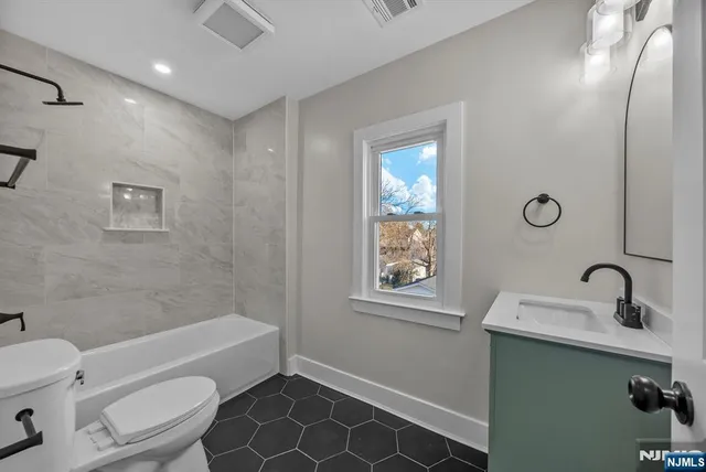 a bathroom with a sink mirror toilet and bathtub