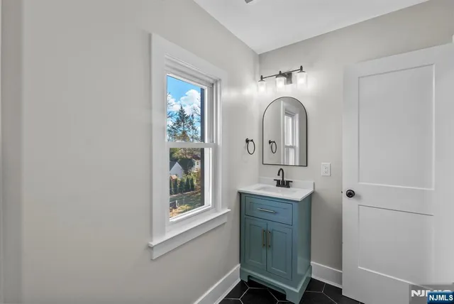 a bathroom with a sink mirror and a window