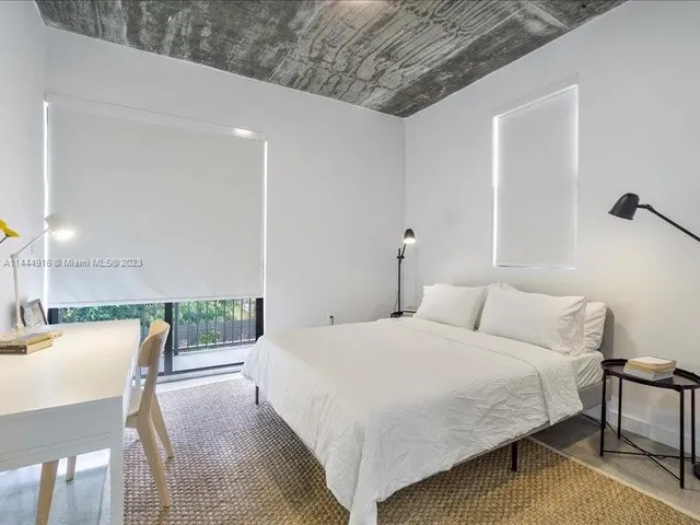 a bedroom with a bed a table and chair