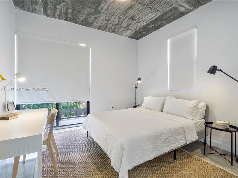 1053 Northwest 29th Street Miami, FL 33127 - Photo 11 of 38 a bedroom with a bed a table and chair