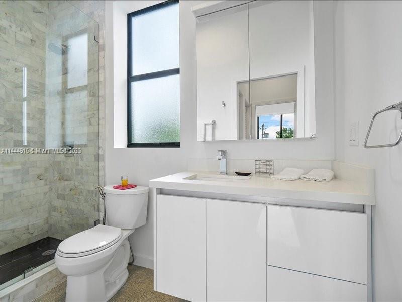 1053 Northwest 29th Street Miami, FL 33127 - Photo 22 of 38 a bathroom with a toilet sink and mirror