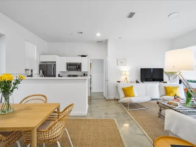a living room with furniture kitchen view and a flat screen tv