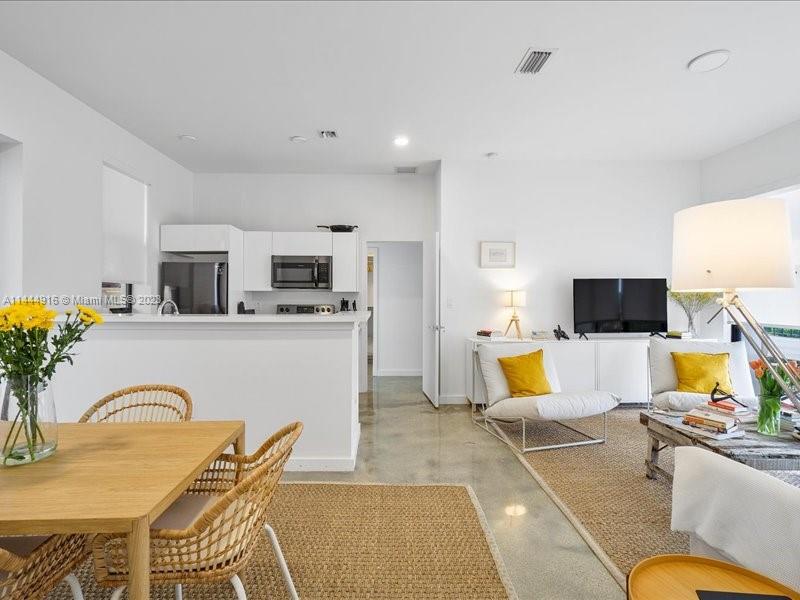 1053 Northwest 29th Street Miami, FL 33127 - Photo 23 of 38 a living room with furniture kitchen view and a flat screen tv