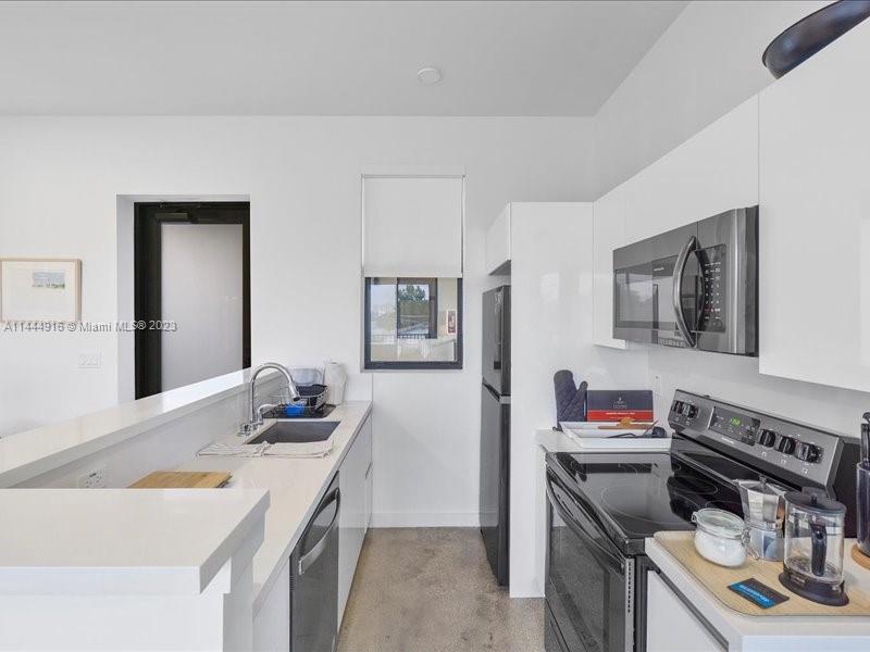 1053 Northwest 29th Street Miami, FL 33127 - Photo 25 of 38 a kitchen that has a sink and a stove in it