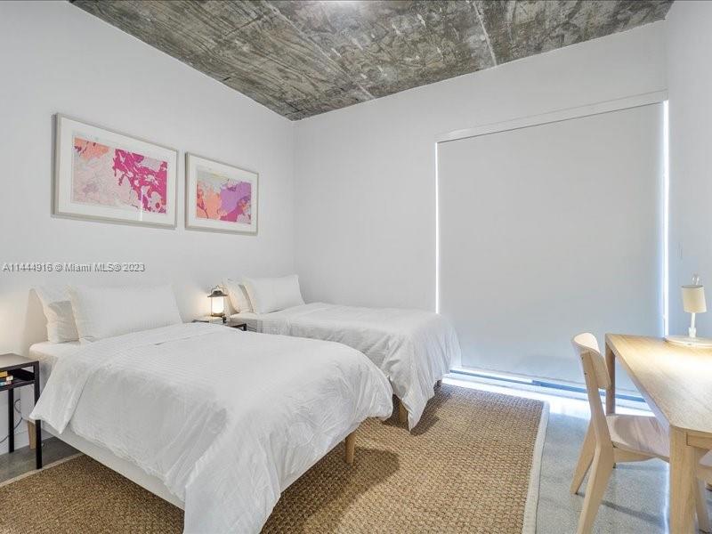 1053 Northwest 29th Street Miami, FL 33127 - Photo 7 of 38 a bedroom with a bed and a table