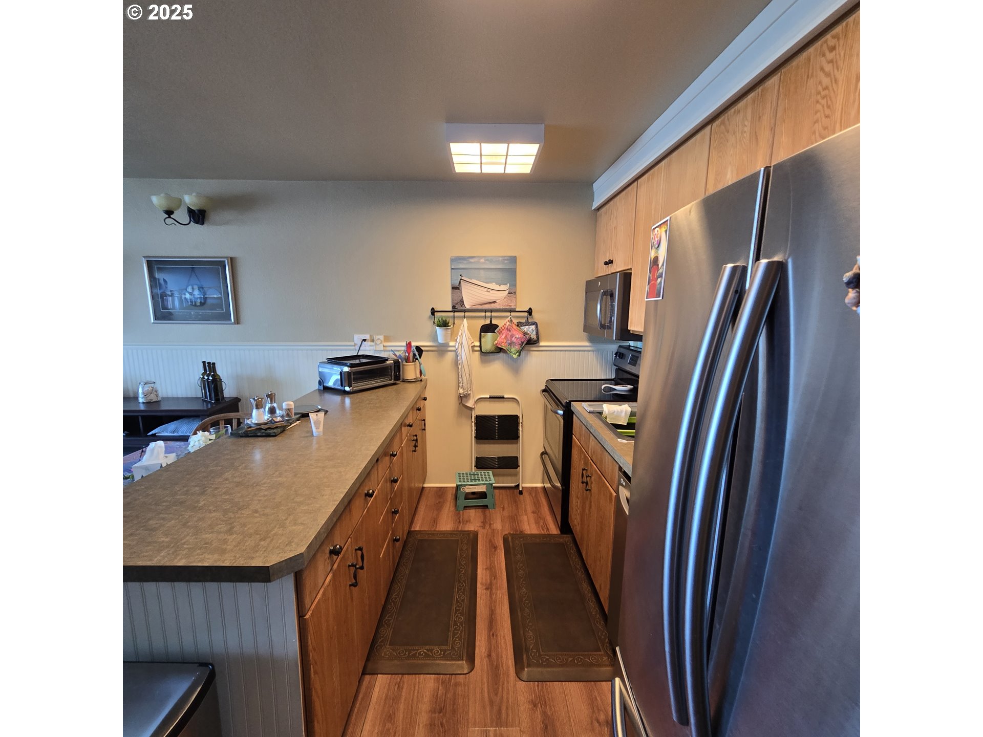 1000 Southeast Bay Blvd. Boulevard, Unit 124 Newport, OR 97365 - Photo 4 of 22 a view of a kitchen with refrigerator and a stove
