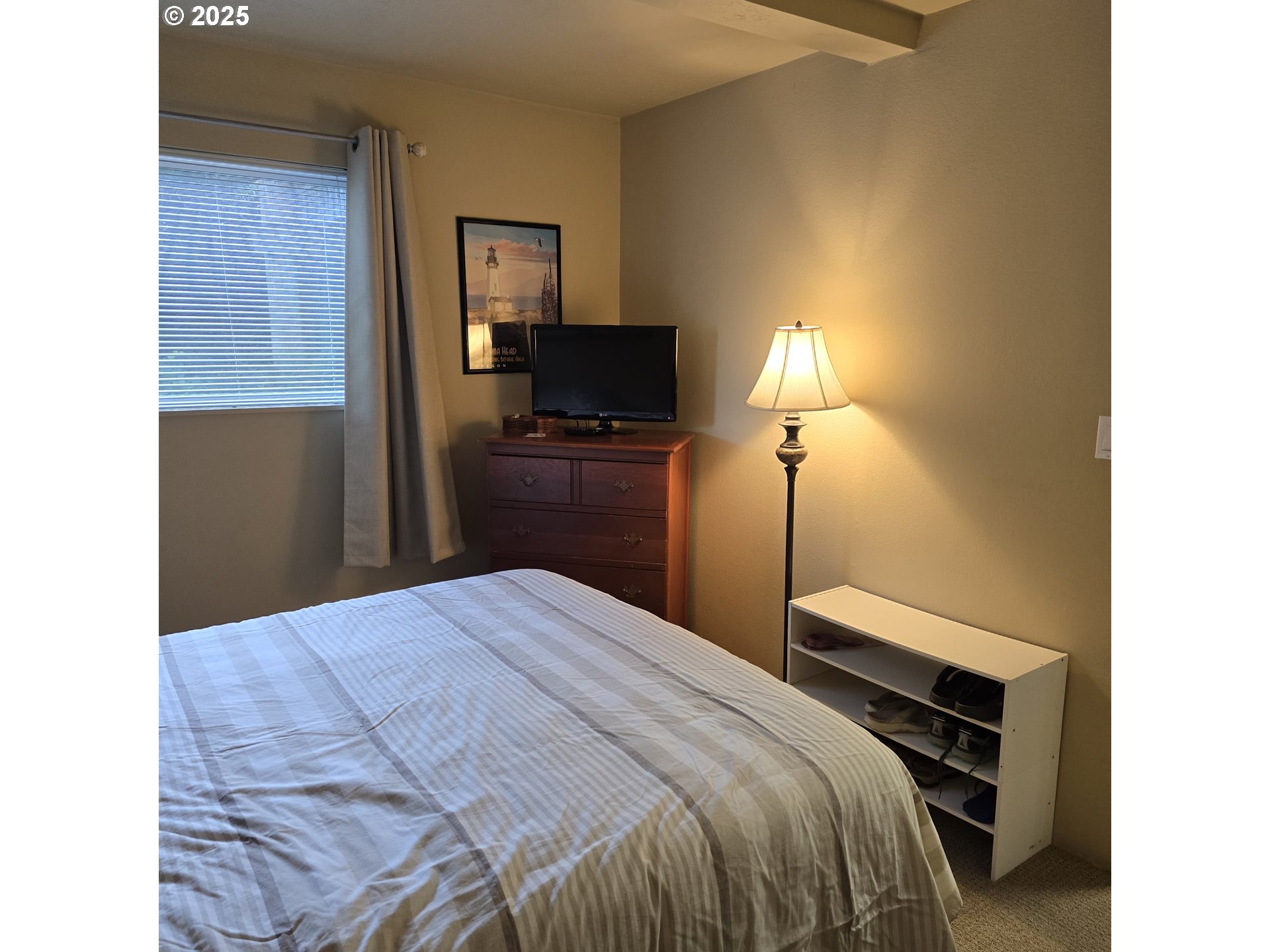1000 Southeast Bay Blvd. Boulevard, Unit 124 Newport, OR 97365 - Photo 10 of 22 a bedroom with a bed and a lamp