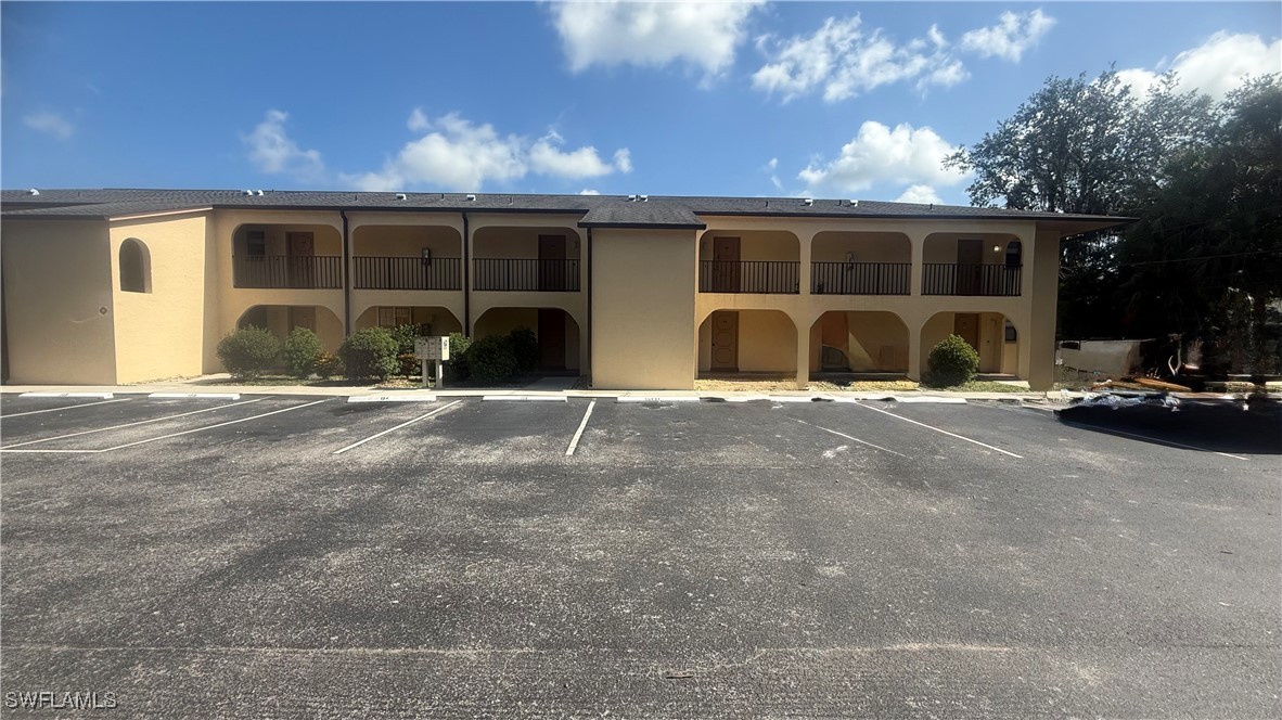 606 Gerald Avenue, Unit 115 Lehigh Acres, FL 33936 - Photo 1 of 7 a view of a house with floor to ceiling windows and a basket ball poll