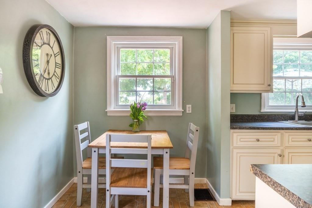 70 Brae Road Weymouth, MA 02191 - Photo 5 of 16 a kitchen with a table chairs a clock on the wall and a window