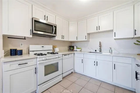 a kitchen with white cabinets stainless steel appliances and sink