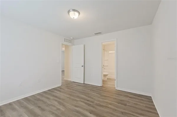a view of an empty room with wooden floor