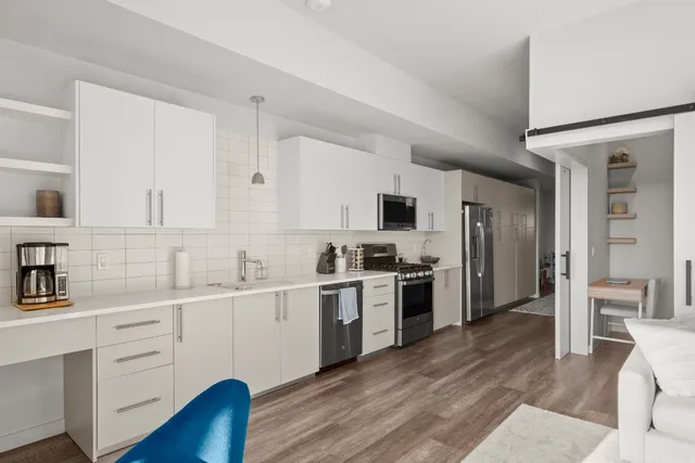 a kitchen with white cabinets and white appliances