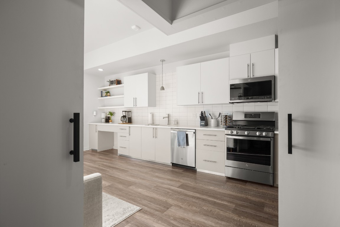 4004 Banister Lane, Unit 202 Austin, TX 78704 - Photo 17 of 23 a kitchen with stainless steel appliances white cabinets a sink a stove a microwave and cabinetry