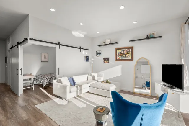 a living room with furniture a flat screen tv and a table