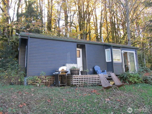 a view of a house with a small yard and a large tree