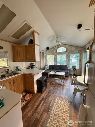 a kitchen with a sink dishwasher a dining table and chairs with wooden floor